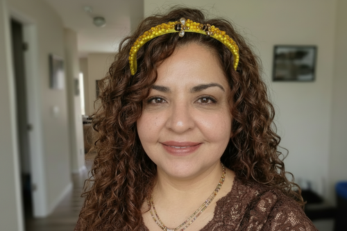 Model wearing yellow beaded headband with bee charms